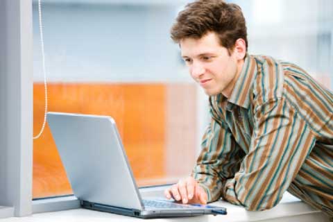 Man researching roofing industry on a lap top computer